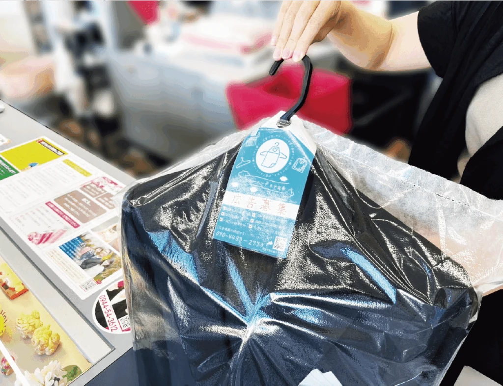 店舗で広告タグを付けた衣類をお渡しする場面